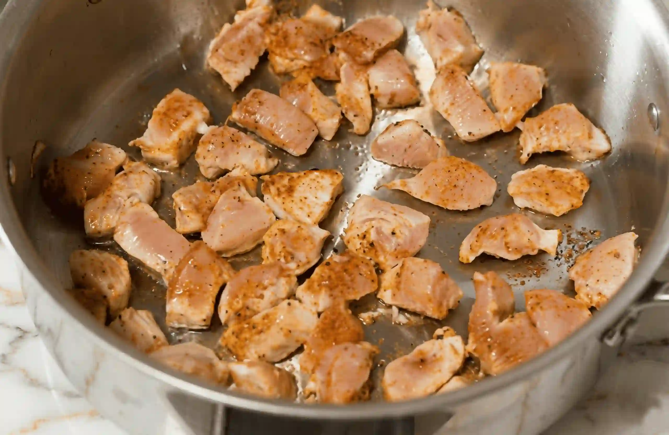 Browning seasoned chicken pieces in a large pot for one pot Cajun chicken pasta