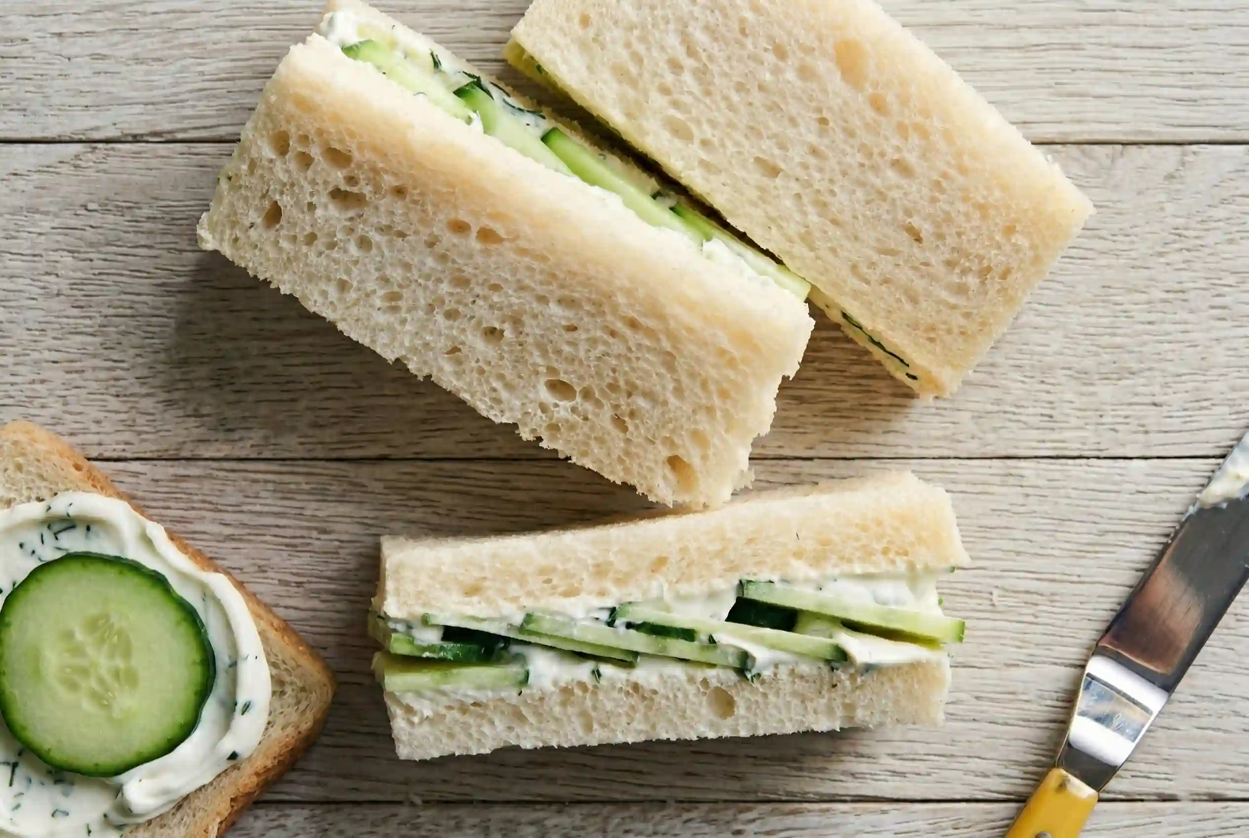 cucumber-cottage-cheese-sandwich-closeup Close up of a sliced cucumber cottage cheese sandwich showing creamy filling and cucumber layers