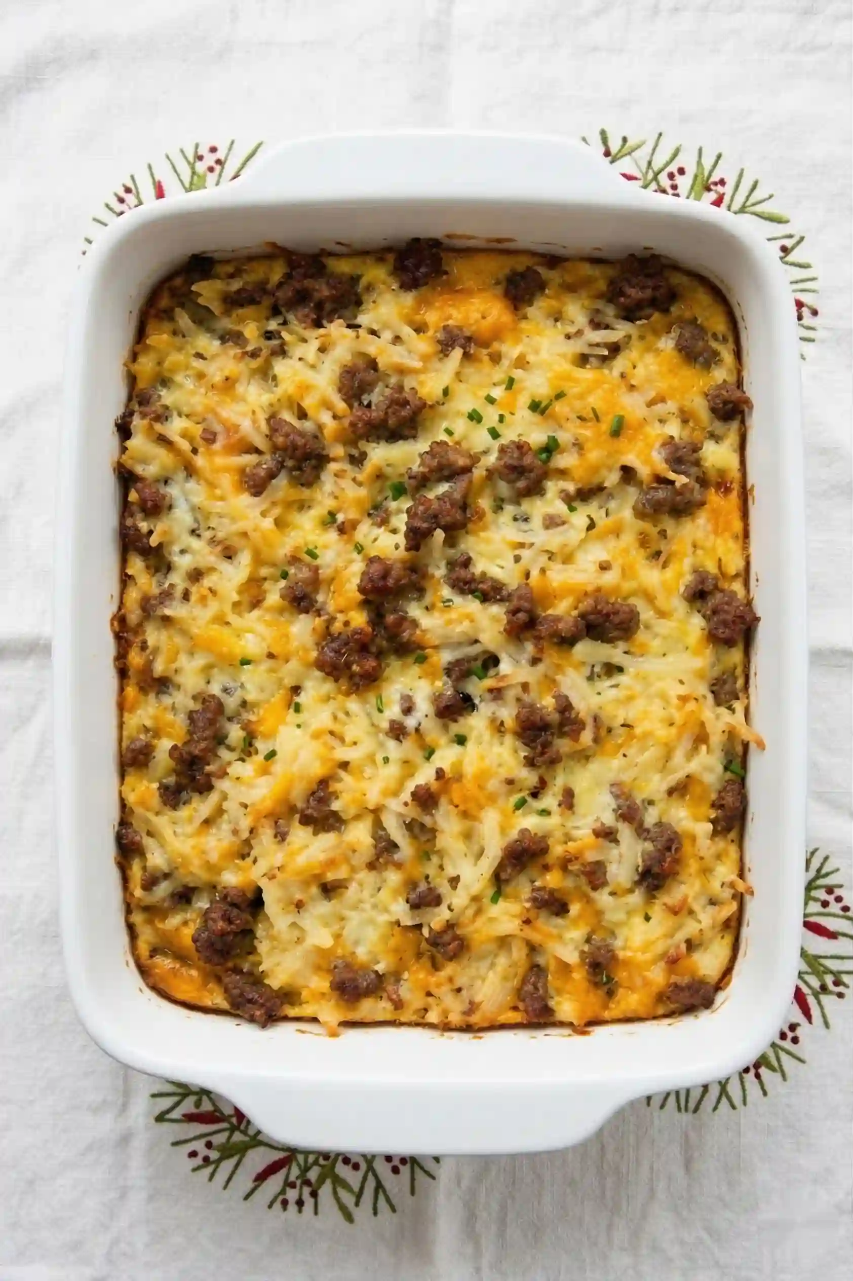 Sliced sausage egg hash brown casserole cheese pull closeup