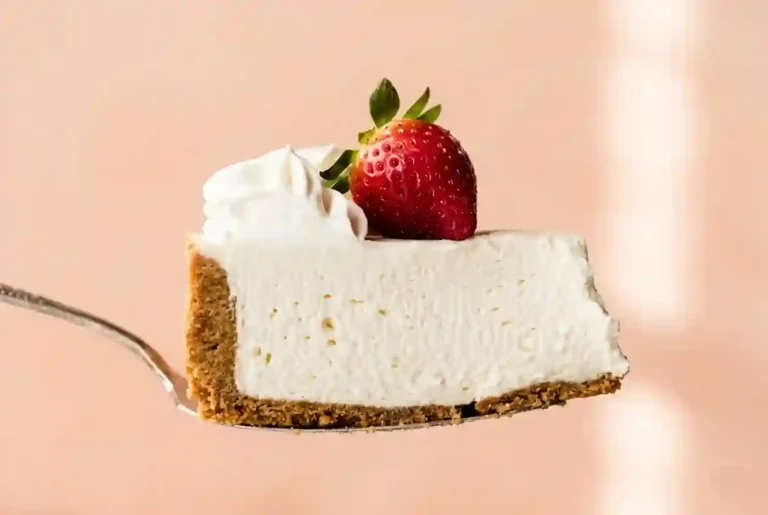 Final no bake cheesecake on a serving plate with strawberry topping
