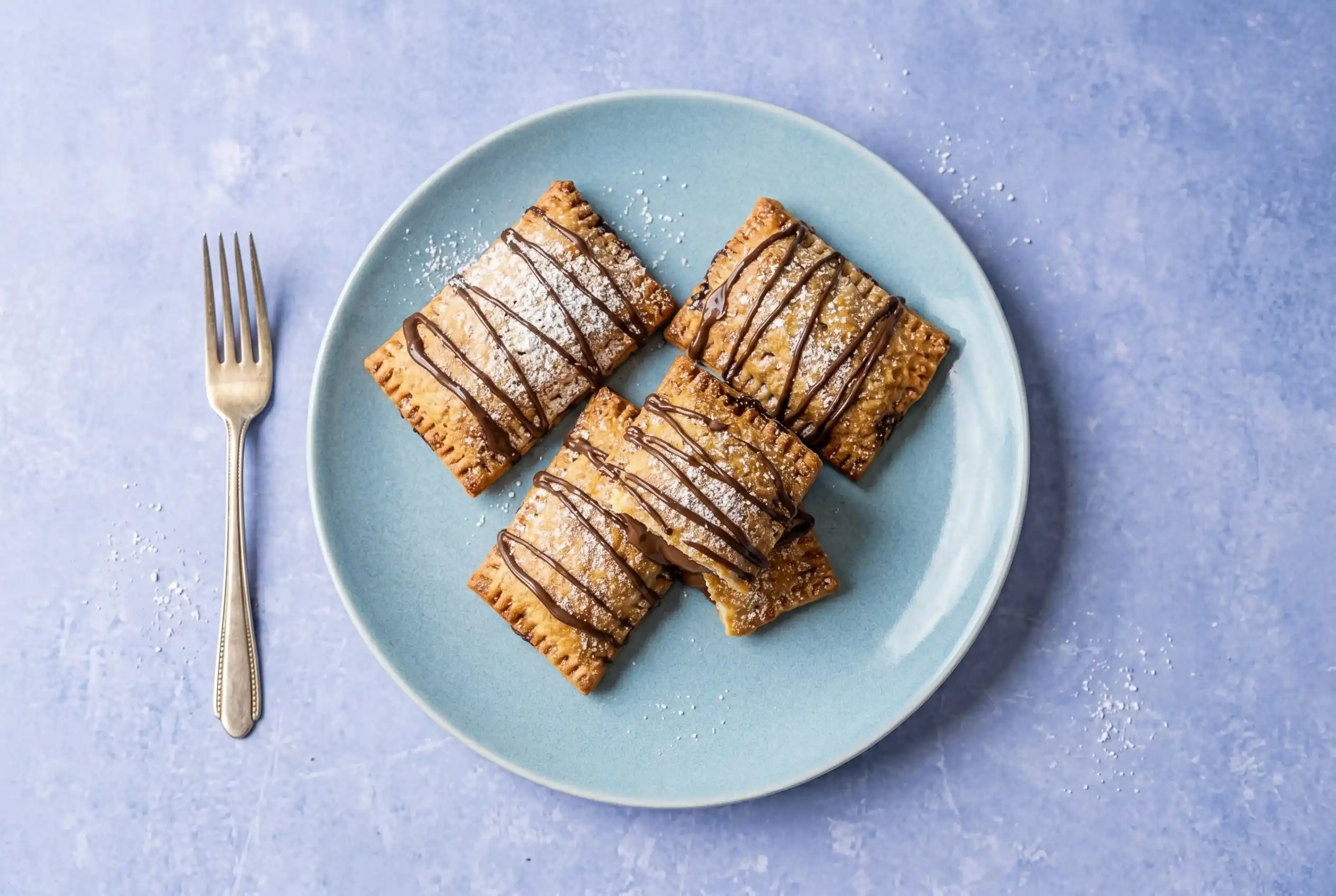 Easy air fryer Nutella toast pies recipe served on marble surface with powdered sugar