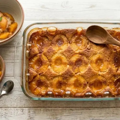 A warm scoop of freshly baked canned peach cobbler with a golden-brown buttery crust and juicy peaches from MixoRecipes.