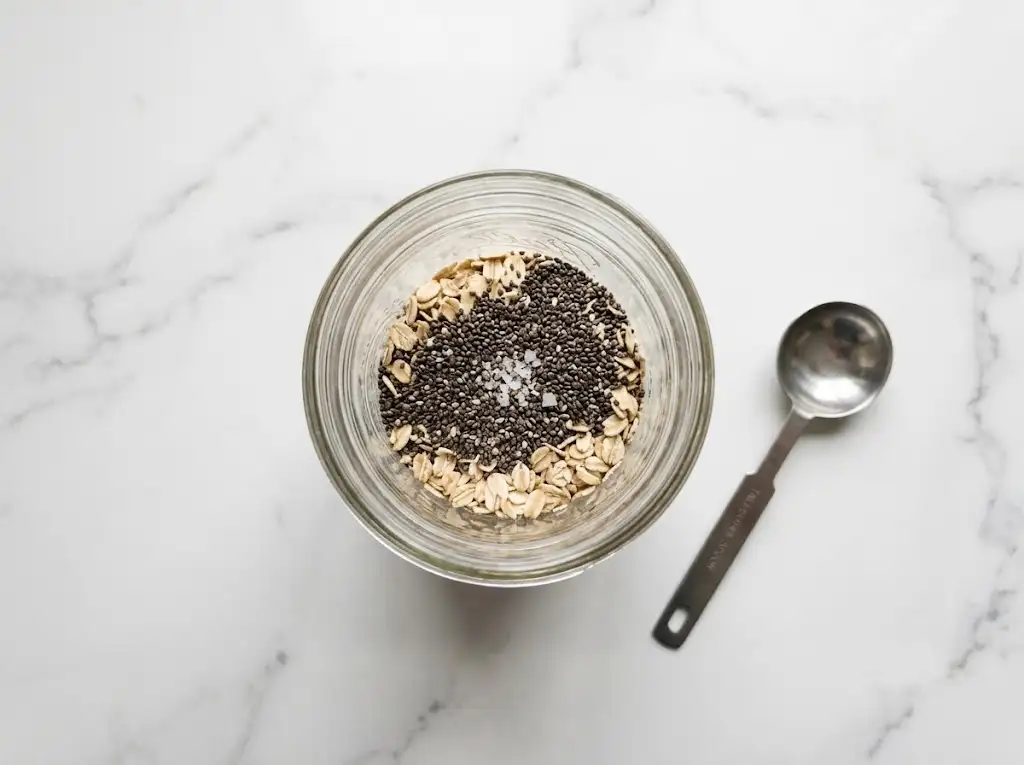Rolled oats, chia seeds, and salt added to a mason jar for peanut butter overnight oats