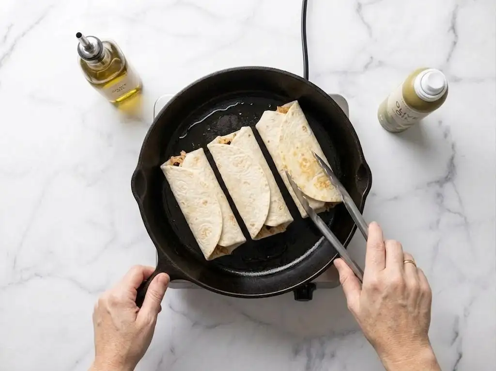 Toasting a Chicken Caesar Wrap in a skillet until lightly golden and crisp.